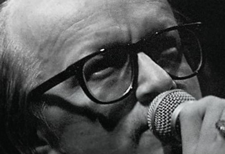 Kuvassa on Juice Leskisen kasvokuva ja hän laulaa mikrofoniin.  Kuva on mustavalkoinen.