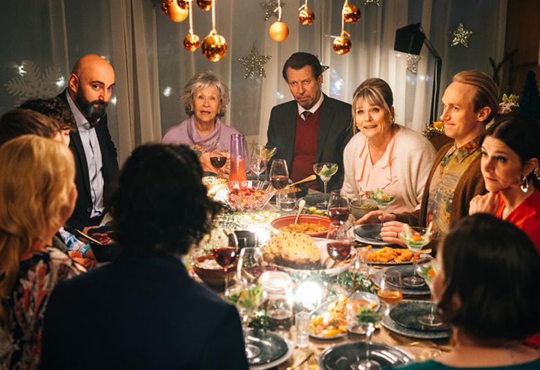 Kuvassa ovat kaikki näyttelijät joulupöydässä syömässä ja keskustelemassa.