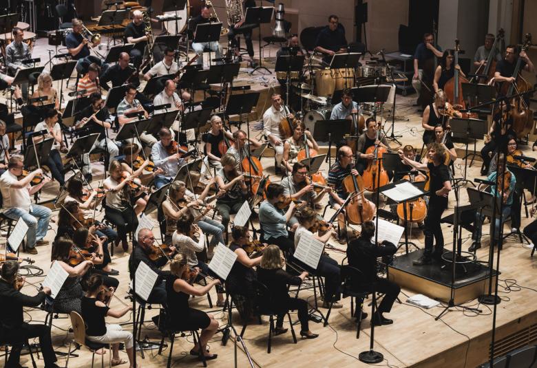 Kuvassa on Tampere Filharmonian soittajat kuvattuna hieman ylhäältä päin ja sivusta.