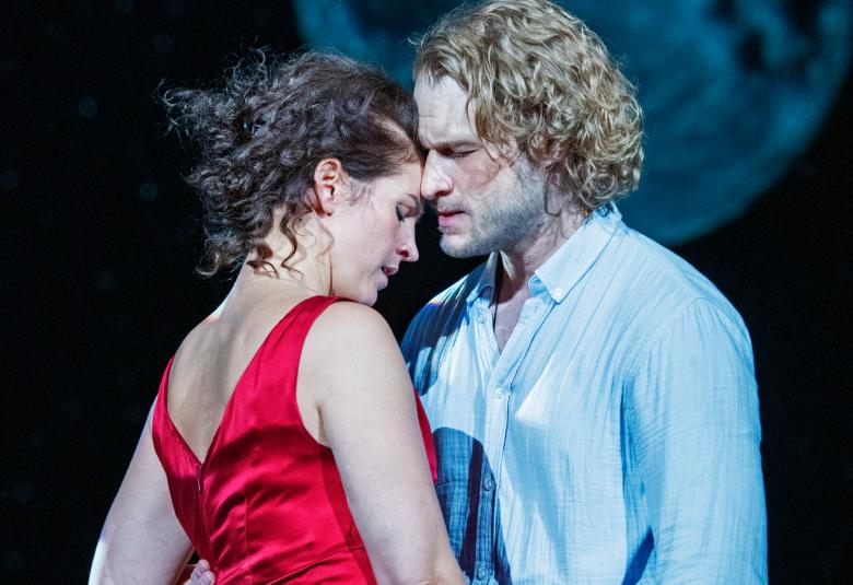 Kuvassa on Maria Ylipää istumassa ylärapulla ja nojaten piharakennuksen seinään ja kirjoittamassa.  Taustalla näykyy Jonas Saaren hahmo.  Kuva on sinisävyinen.