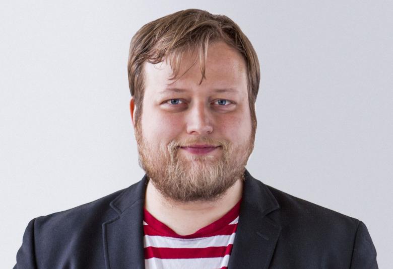 Kuvassa on Lauri Maijala puolivartalokuvassa mustassa pikkutakissa puna-valkoraitaisessa t-paidassa.