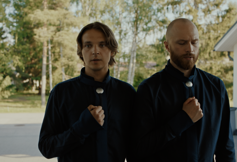 Kuvassa ovat Roope Salminen ja Eino Heiskanen seisomassa pihalla, jonka taustalla näkyy vihreitä lehtipuita. 