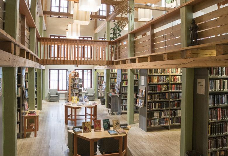 Kuvassa näkyy Tyrnävän kirjaston hyllyjä ja miljöötä, joka on vanhahtavan historiallisen näköinen ja ruskehtavaa väriltään.