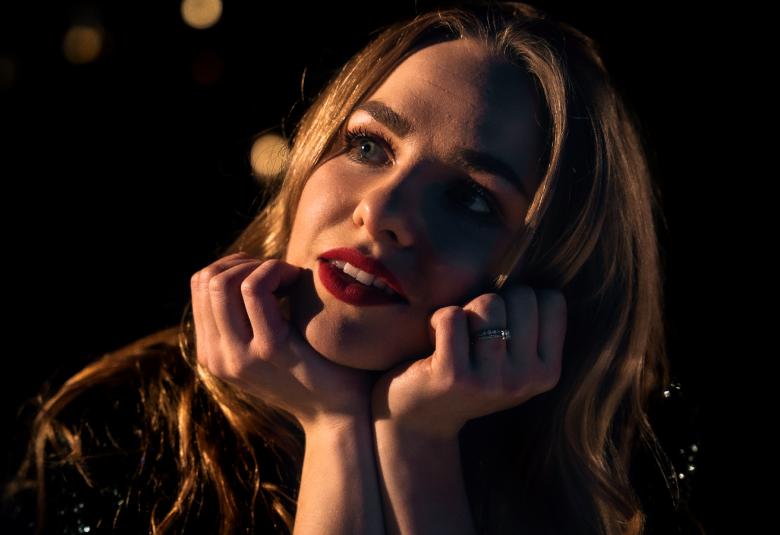 Kuvassa on Iltan kasvot ja hän katsoo vinosti oikealle.  Kuvan sävy on tumma. 