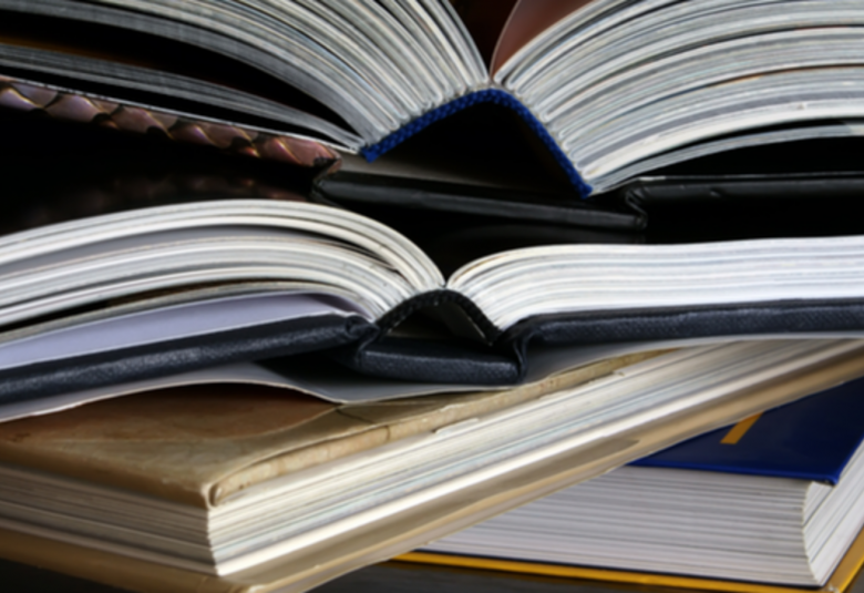 Kuvassa on avattuja kirjoja pinossa.