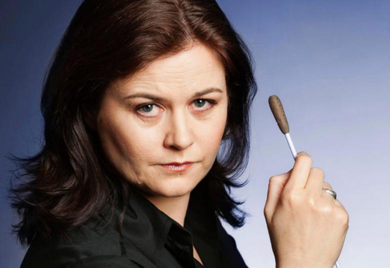 Kuvassa on kasvokuva Anna-Maria Helsingistä ja hänellä on kädessään tahtipuikko.  Hänen hiuksensa ovat tummat.