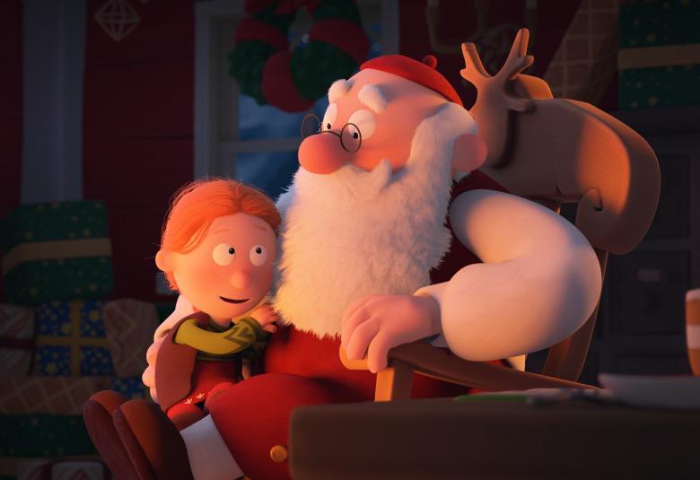 Kuvassa on Mauri Kunnaksen animaatiohahmoina Joulupukki ja hänen sylissään on pikkutyttö. Taustalla on tuolin selkämyksellä poronsarvet.