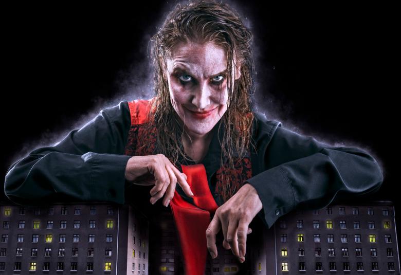 Kuvassa on Vappu Nalbantoglu vampyyrimäisessä meikkauksessa ja tummissa vaatteissa.  Hän seisoo ja pitää käsiään kahteen osaan jaetusta tummien kerrostalojen pienoismallien päällä.  Keskellä on aukio, jossa on käveleviä ihmisten pienoismalleja.