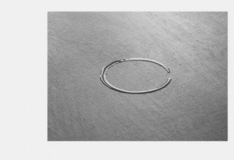 Kuvassa on harmaalla pohjalla hopeinen soikio.