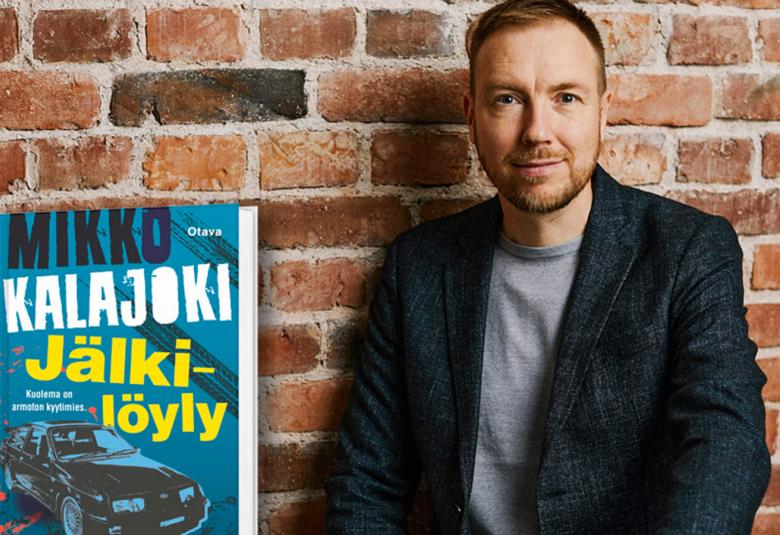 Kuvassa on Mikko Kalajoki puolivartalokuvassa ja hänellä on musta takki ja harmaa t-paita päällään.  Taustalla on tiiliseinää.  Kirjan kansi on vasemmalla ja siinä on kannessa mm. autoja.