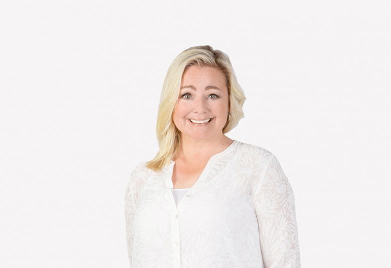 Kuvassa on Susanna Palin, jolla on valkoinen pusero päällään ja kuvan tausta on valkoinen.