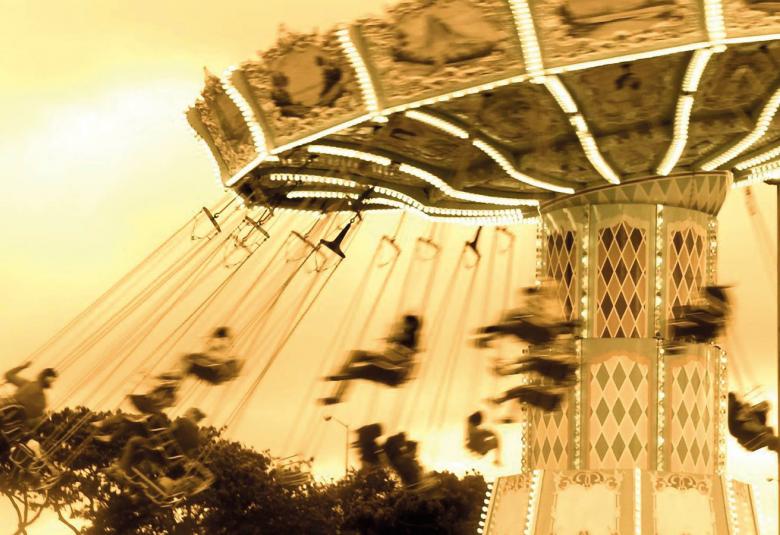 Kuvassa on keltaisella pohjalla ruskea karuselli.  Kuva on piirretty.