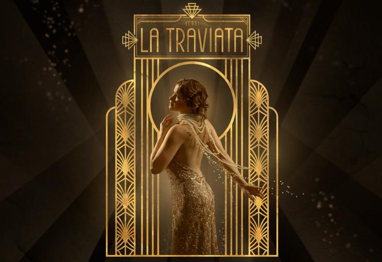 Kuvassa on kullanväristen pylväiden välissä ja yläpuolella lukee kullatulla pohjalla La Taviata ja kuvassa on kapea portti. Edessä on Marjukka Tepponen kullan värisessä pitkässä puvussa. Molemmilla sivuilla on tummaa.