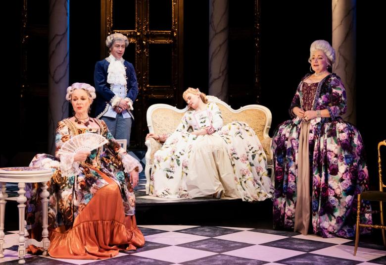 Kuvassa on näyttävissä pitkissä kukkakuvioisissa pönkkähameissa ja peruukeissa kolme naista, joista vasemmalla istuu yksi ja pitää viuhkaa.  Keskellä on sohvalla istuen nukkuva nuori nainen ja hänen takanaan seisoo vanhempi nainen.  Vasemmalla taustalla seisoo mies tummassa livre-takissa ja valkoisessa röyhelöpaidassa.