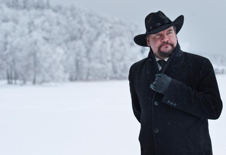 Kuvassa on Kalevi Kiviniemi oikeassa reunassa mustassa talvitakissa ja lierihatussa.  Taustalla on lumimaisemaa