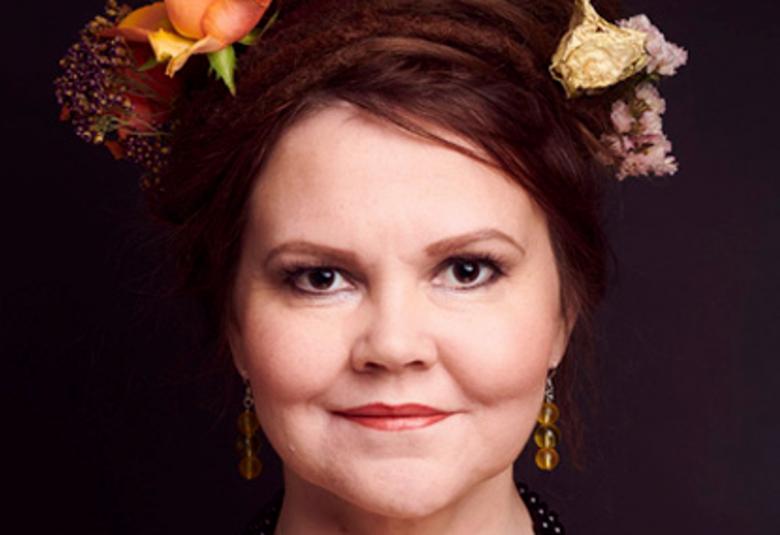 Kuvassa on Katja Ketun kasvot ja hänellä on tummat hiukset, joissa on ruusuja.