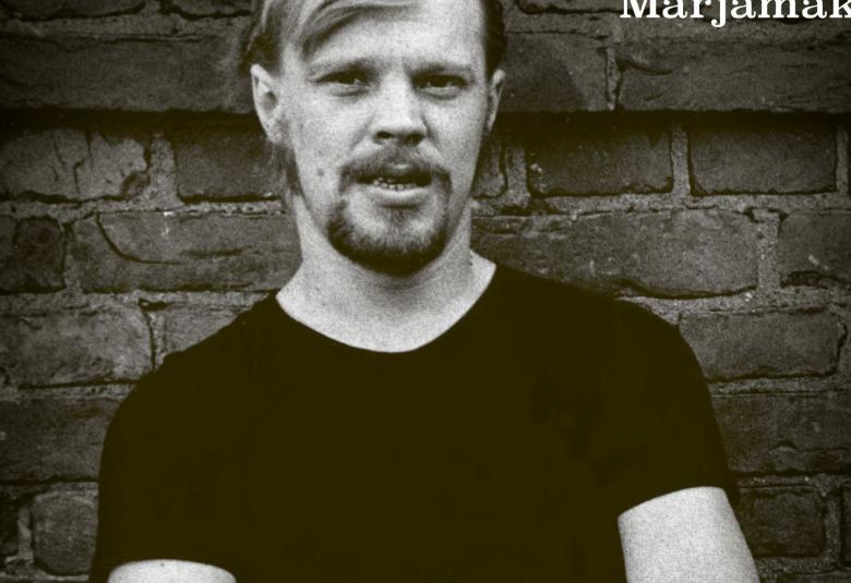 Kuvassa on osa kirjan kannesta ja Veskusta on puolivartalokuva mustassa t-paidassa.  Kuva on nuoruuden kuva ja musta-valkoinen.