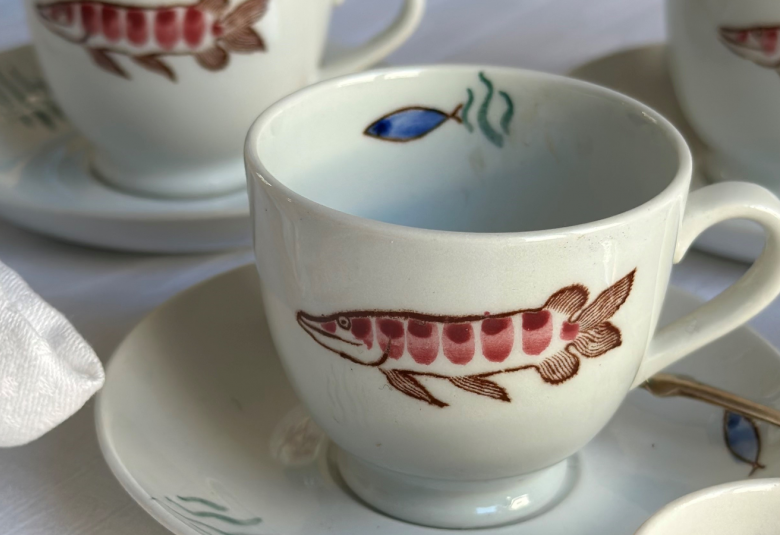 Kuvassa on valkoisia kahvikuppeja, joissa on ruskehtava kalan kuva.