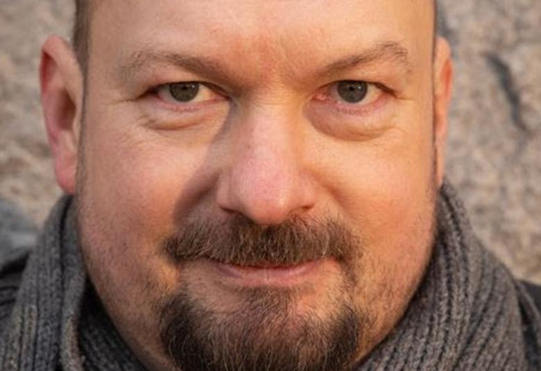 Kuvassa Kristian Smeds kasvokuvassa. Hänellä on viikset ja leukaparta.