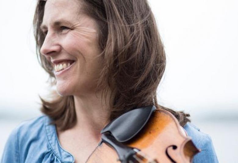 Kuvassa on Cecilia Zilliacus puolivartalokuvassa, jossa hän on sivuttain.  Hänellä on vaalean sininen pusero päällään ja viulu olkapäällään.