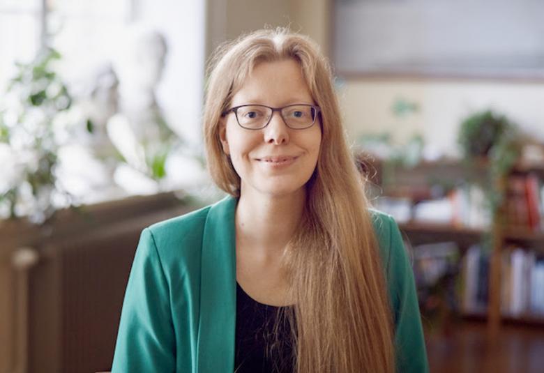 Kuvassa on Sofia Kotilainen puolivartalokuvassa seisomassa huoneessa, jossa on taustalla puolen seinän kirjahylly.  Vasemmalla on korkea ikkuna. Kotilaisella on pitkät vaaleat hiukset. 