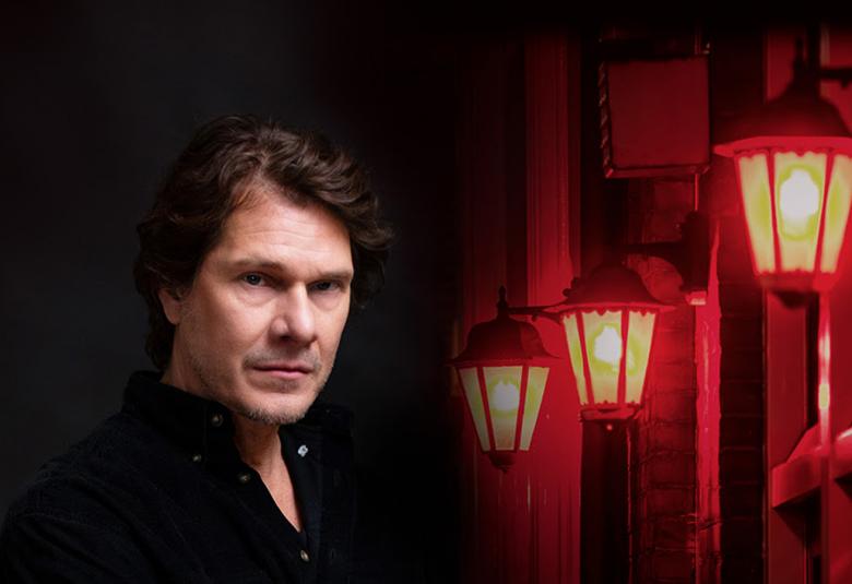 Kuvassa on Kari-Pekka Toivonen puolivartalokuvassa ja taustasta puolet on tummaa ja oikealla on punaisia lyhtyjä.