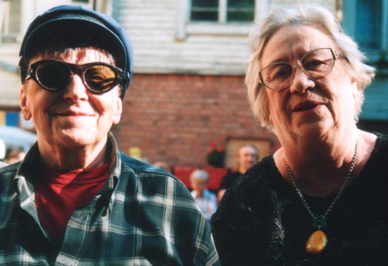 Kuvassa on Verna Tervaharju harmaan betoniseinän vieressä, johon tulee muraali.