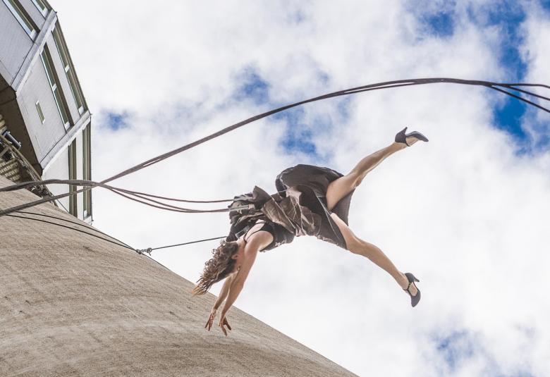 Kuvassa on tanssija tulossa vaijereissa vauhdikkaasti alas Puijon tornin pintaa pitkin.