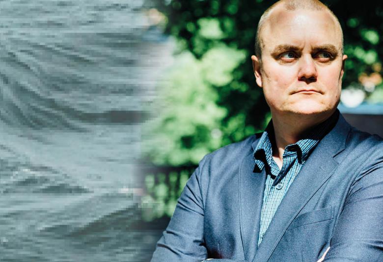 Kuvassa on vasemmalla harmaata aaltoliikettä. Oikealla on Patrik Berghållin kasvokuva. 