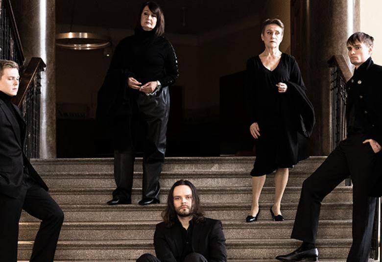 Kuvassa on portailla ylhäällä seisomassa kaksi naisnäyttelijää ja portaikon kaiteiden molemmin puolin nuoret miesnäyttelijät. Keskellä istumassa portailla yksi miesnäyttelijä.