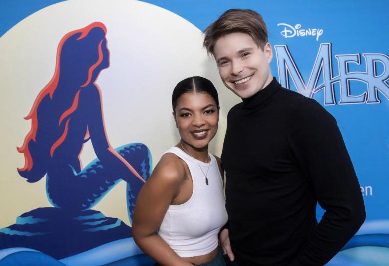 Kuvassa ovat Yasmine Yamajako vasemmalla ja Martti Manninen oikealla seisomassa puolivartalokuvassa.  Taustalla on Merenneito-juliste.