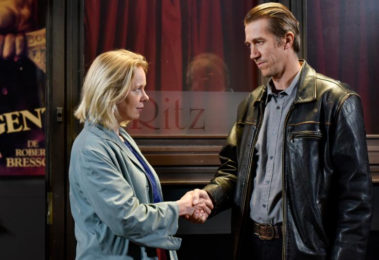 Kuvassa ovat Alma Pöysti vaalean sinisessä takissa ja Jussi Vatanen mustassa nahkatakissa. He ovat sivukuvassa kättelemässä kanssa.