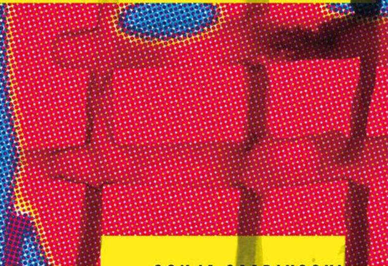 Kuvassa on punaista tiilimäsitä seinää ja siinä on mustia pystysuoria kaltereita ja alhaalla keltainen suorakaide.