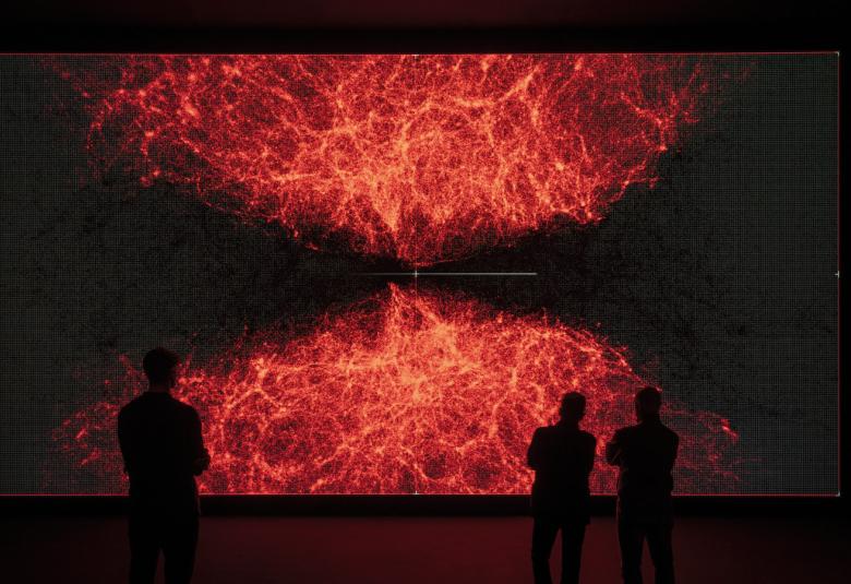 Kuvassa on teos, jossa on mustat reunukset ja alhaalta tulee tulta, joka orannssin punaisena heijastuu ylöspäin.