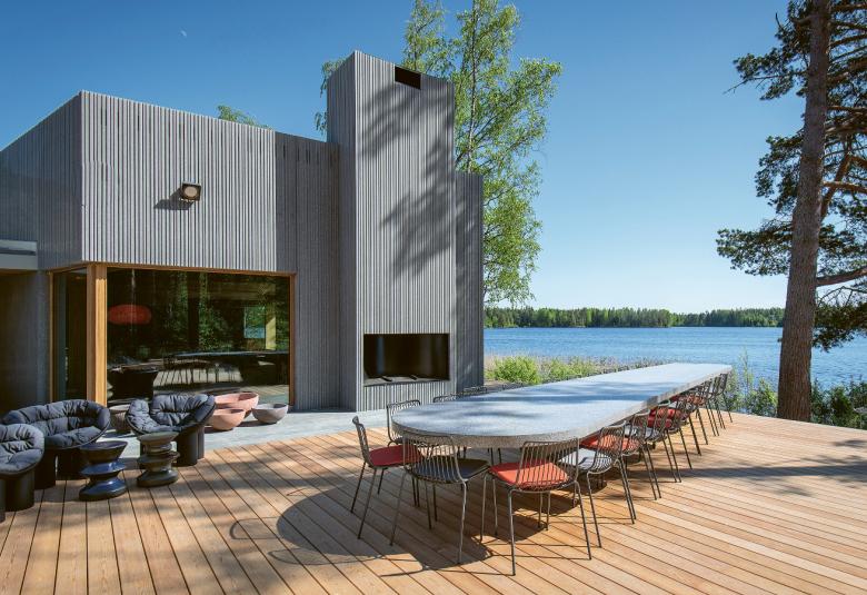 Kuvassa on metsikössä harmaita saunarakennuksia, joista lähimpänä pyöreä rakennus ja kauempana pulpettikattoinen rakennus.