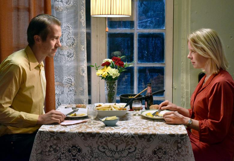 Kuvassa ovat Jussi Vatanen kellertävässä paidassa vasemmalla ja Alma Pöysti viininpunaisessa puvussa oikealla syömässä ravintolapöydän ääressä.