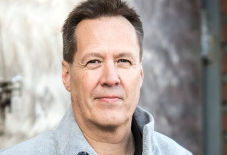 Kuvassa on Kale Puonti ja hänestä on puolivartalokuva.  Kuva on otettu ulkona ja taustalla on vaaleaa seinää.