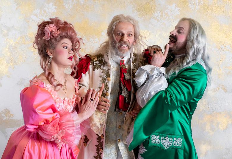 Kuvassa ovat Inke Koskinen vasemmalla vaalean punaisessa pönkkähameessa, Auvo Vihro vaalean kirjavassa takissa ja Hiski Vihertörmä vihreässä takissa. Tuuli on barokkisen näyttävää.