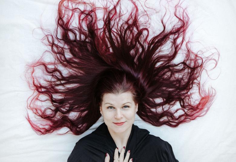 Kuvassa on Elina Pohjola puolivartalokuvassa ja pitkät, violetit hiukset tuuletettuneena ylöspäin. Kuva on osa levyn kannesta.