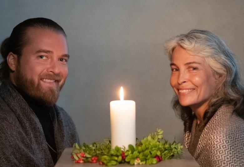 Kuvassa ovat istumassa Teemu Roivainen vasemmalla ja Irina Björklund oikealla. Heistä on puolivartalokuva. Roivaisella on tumman harmaa takki ja Björklundilla vaalea jakku päällään. Heidän keskellään on kynttilänliekki.  