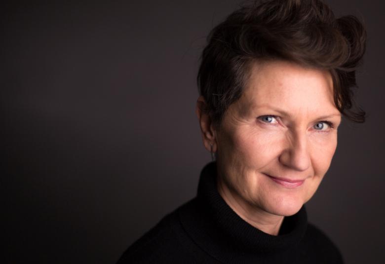 Kuvassa ovat Sirkku Peltolan kasvot kuvan oikealla puolella. Tausta on tumma.