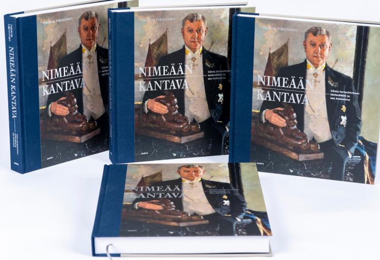 Kuvassa on viisi Nimeään kantava -kirjaa, joista kolme on pystyssä ja kaksi vaakatasossa.  Kirjan pääty on sininen ja siinä on valkoisella nimi. Kannessa on Gösta Serlachiuksen muotokuva ja hänella on frakki ja kaulassaan kunniamerkki.