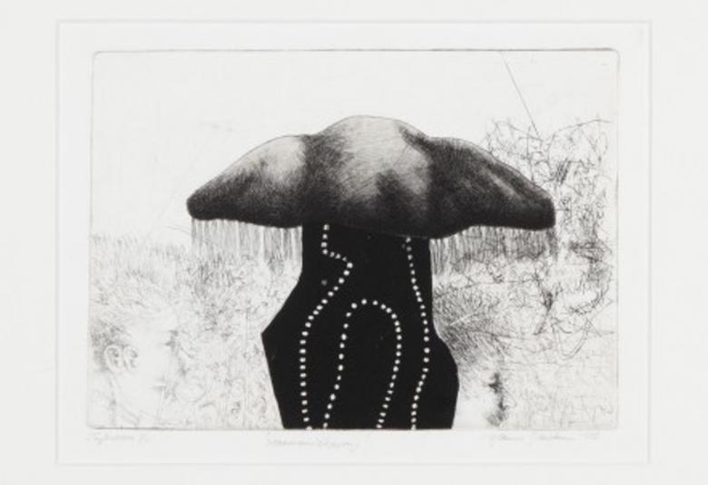 Kuvassa on harmaalla seinällä reunalla kaksi pientä grafiikan työtä ja keskellä vaalean kellertävä teos.  Sen vieressä on kaksi pientä teosta. Lattialla vasemmalla on ohuilla jaloilla oleva pöytä.