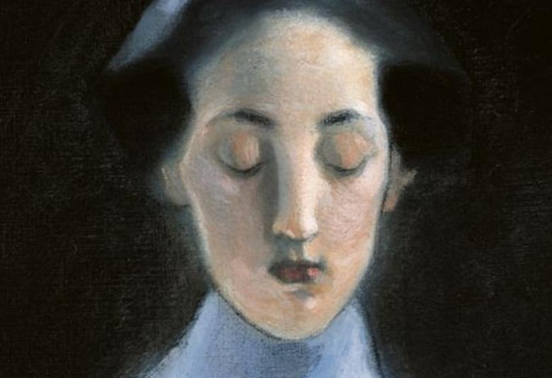 Kuvassa on naisen kasvot ja hän katsoo alaspäin.  Naisella on tummat hiukset ja vaaleansininen paita.  Tausta on musta.