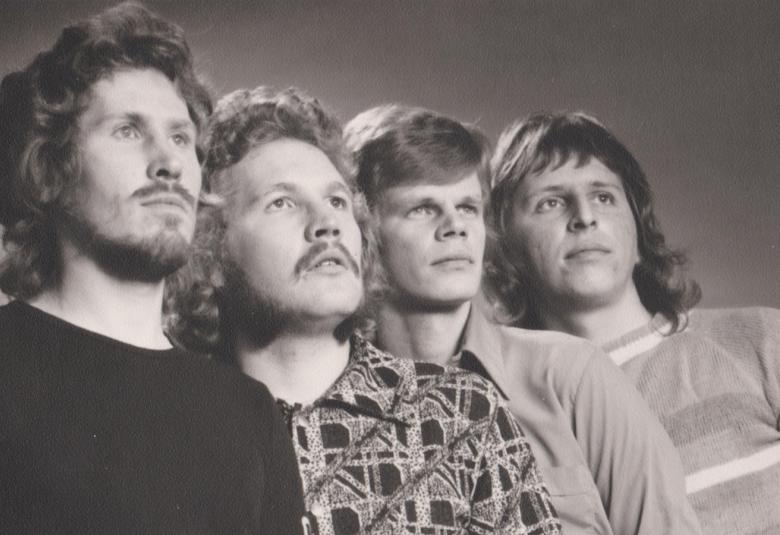 Kuvassa ovat puolivartalokuvassa Kasevan neljä jäsentä.  Heistä ensimmäisellä on musta paita ja muilla kirjavat paidat.  Kuva on musta-valkoinen.