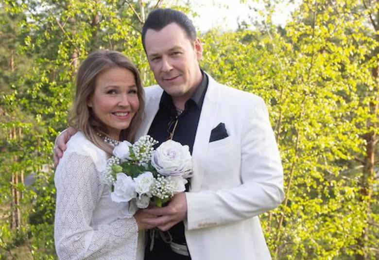 Kuvassa ovat vasemmalla Marita Taavitsainen ja oikealla Kari Hirvonen ja he seisovat lähekkäin.  Heillä on kädessään kimppu valkoisia ruusuja. Taustalla on vihreitä lehtipuita. Molemmilla on valkoiset vaatteet ja Hirvosella on musta paita.