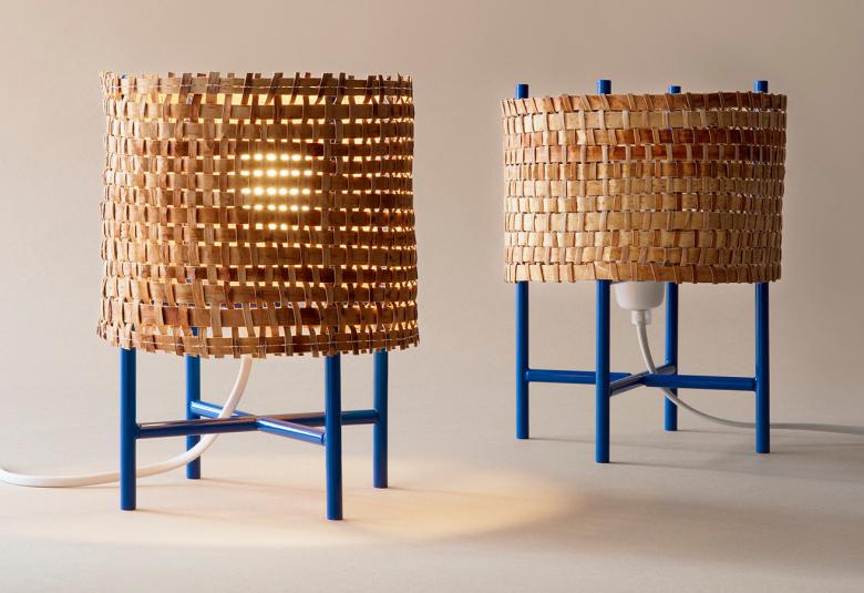 Kuvassa on kaksi sinisillä jaloilla seisovaa jalkalamppua.  Lampun varjostimiet on punottua vaalean ruskeata pajua.