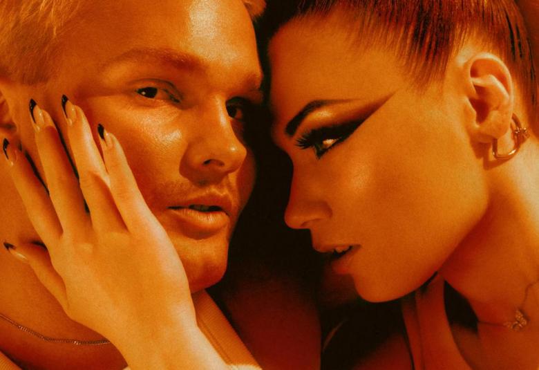 Kuvassa ovat oranssisävytteisessä kuvassa kasvokuvassa makuulla Benjamin ja Bess. Bess katsoo Benjaminia ja pitää oikeaa kämmentään kevyesti Benjamininn poskella.  