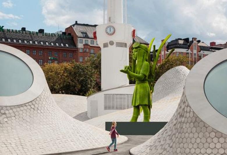 Kuvassa on Amos Rexin pihaa, jossa on vaaleiden kohoumien keskellä ja siinä on keskellä iso vihreä Vaeltaja-veistos. Keskellä takana on kellotapuli.