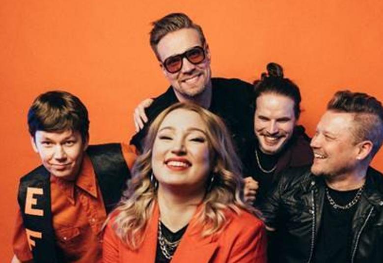 Kuvassa ovat Ilmari Aitoaho, Matias Kiiveri, Janne Kinnunen ja edessä Taru Ratilainen ja Tomi Salesvuo. Tausta on oranssi ja Aitoaholla on musta liivi ja oranssi paita sekä Taru Ratilaisella oranssi jakku ja musta paita. Muilla on mustat vaatteet.